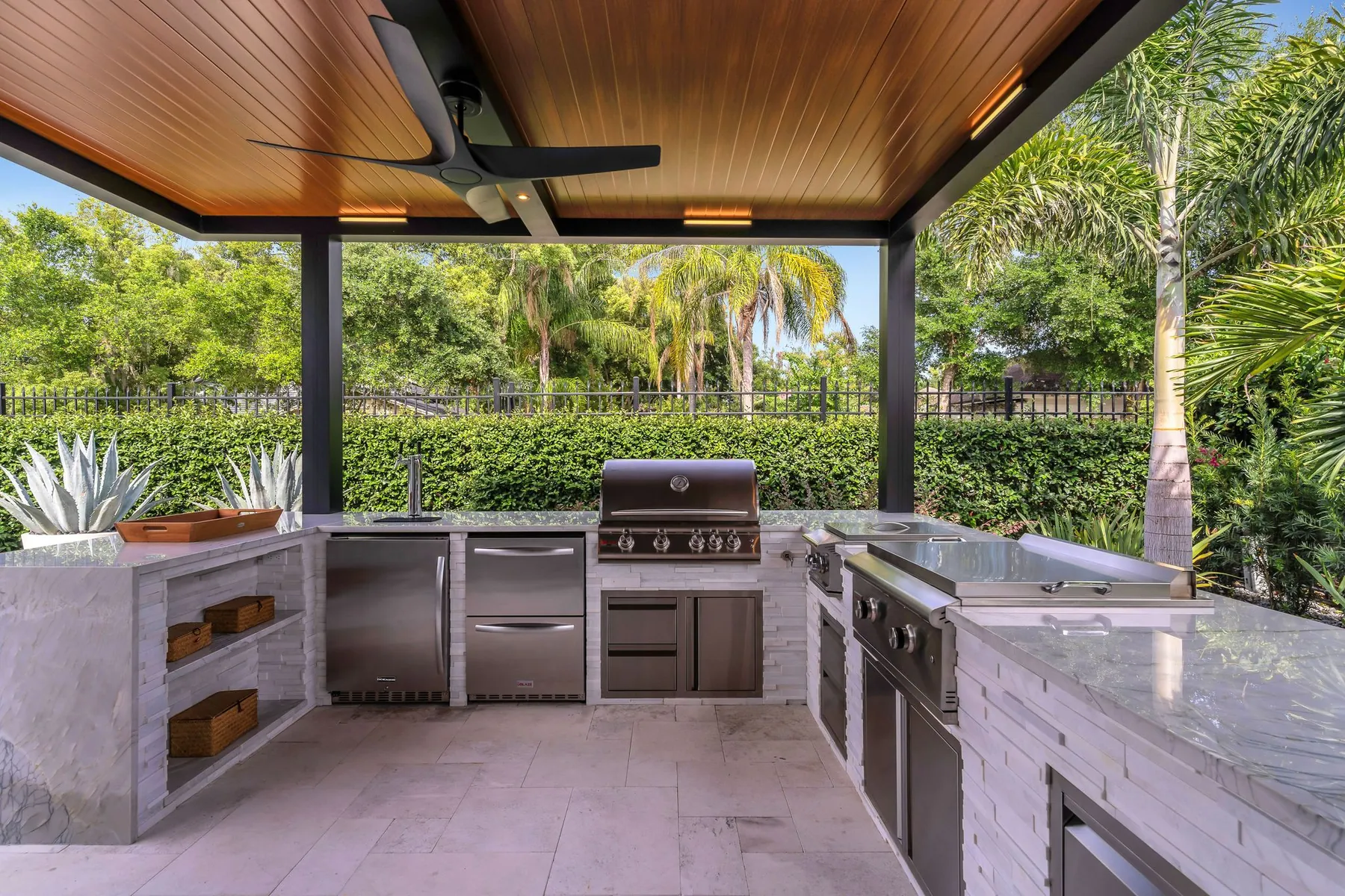 Custom outdoor kitchen with a wood-grain louvered cover by Patio Style, near Orlando, FL