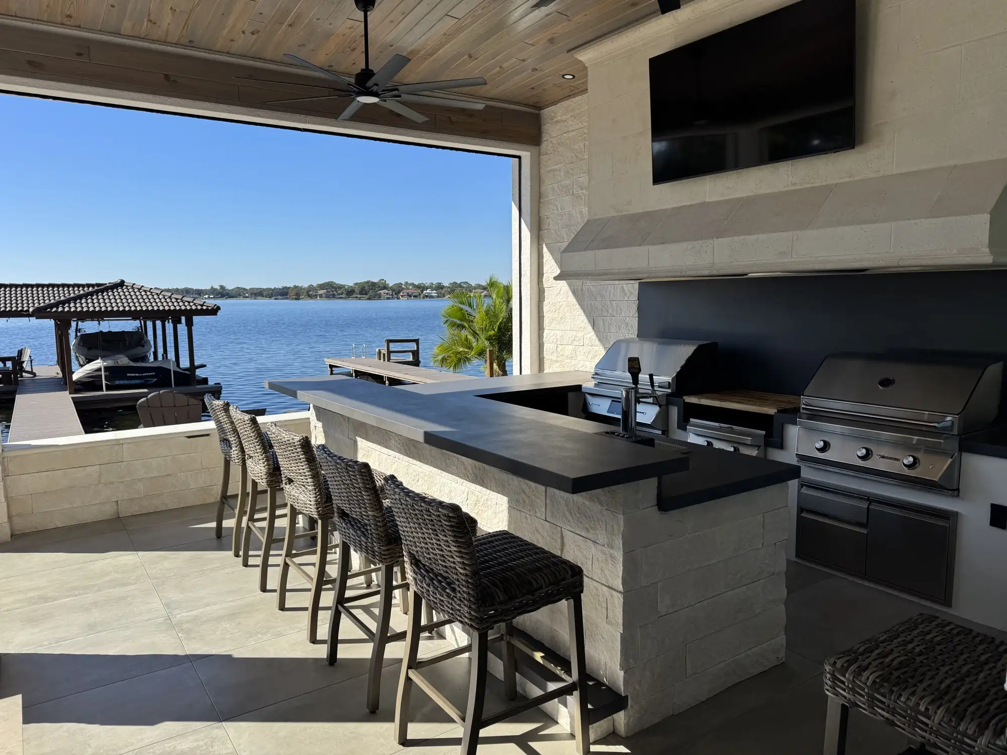 The finished outdoor kitchen and bar overlooking the lake in Apopka, FL