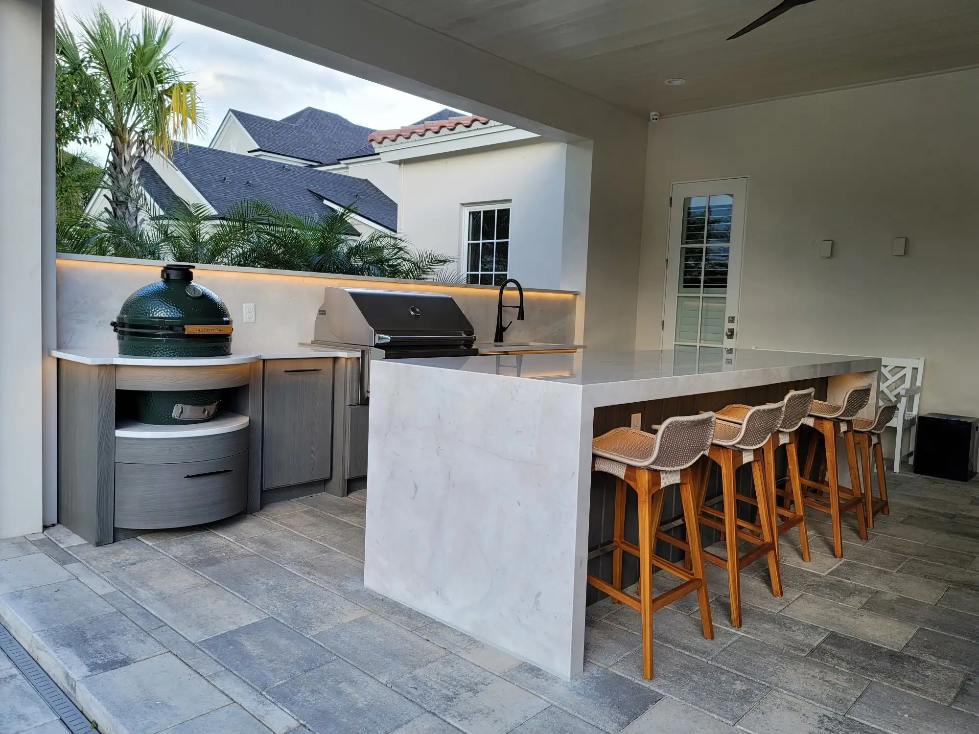 Outdoor kitchen bar seating in Orlando, with woven barstools along a marble counter