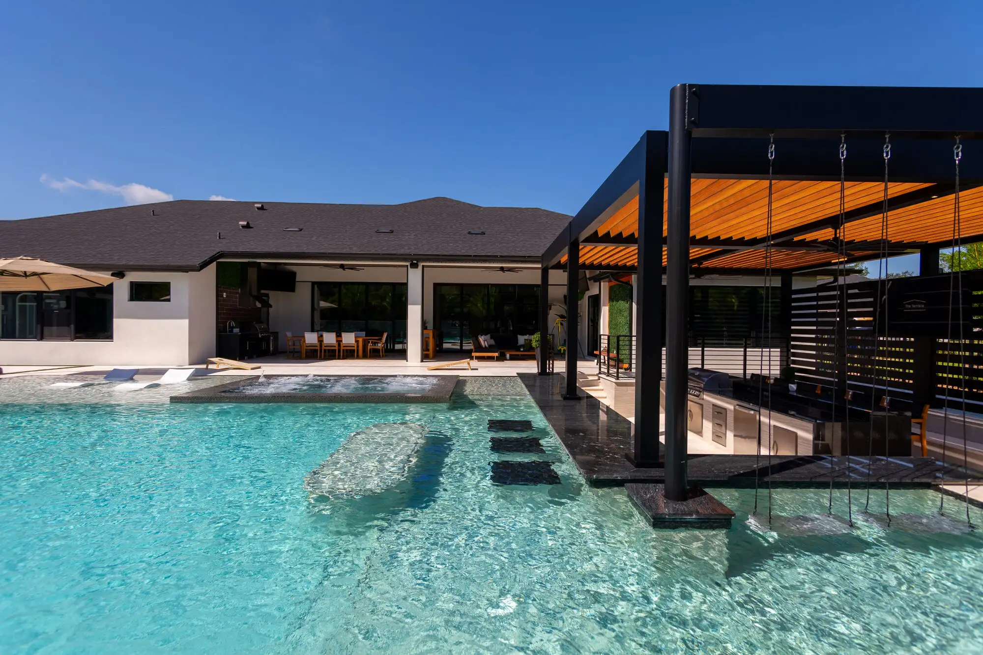 Black aluminum louvered pergola over the pool deck in New Smyrna Beach, FL